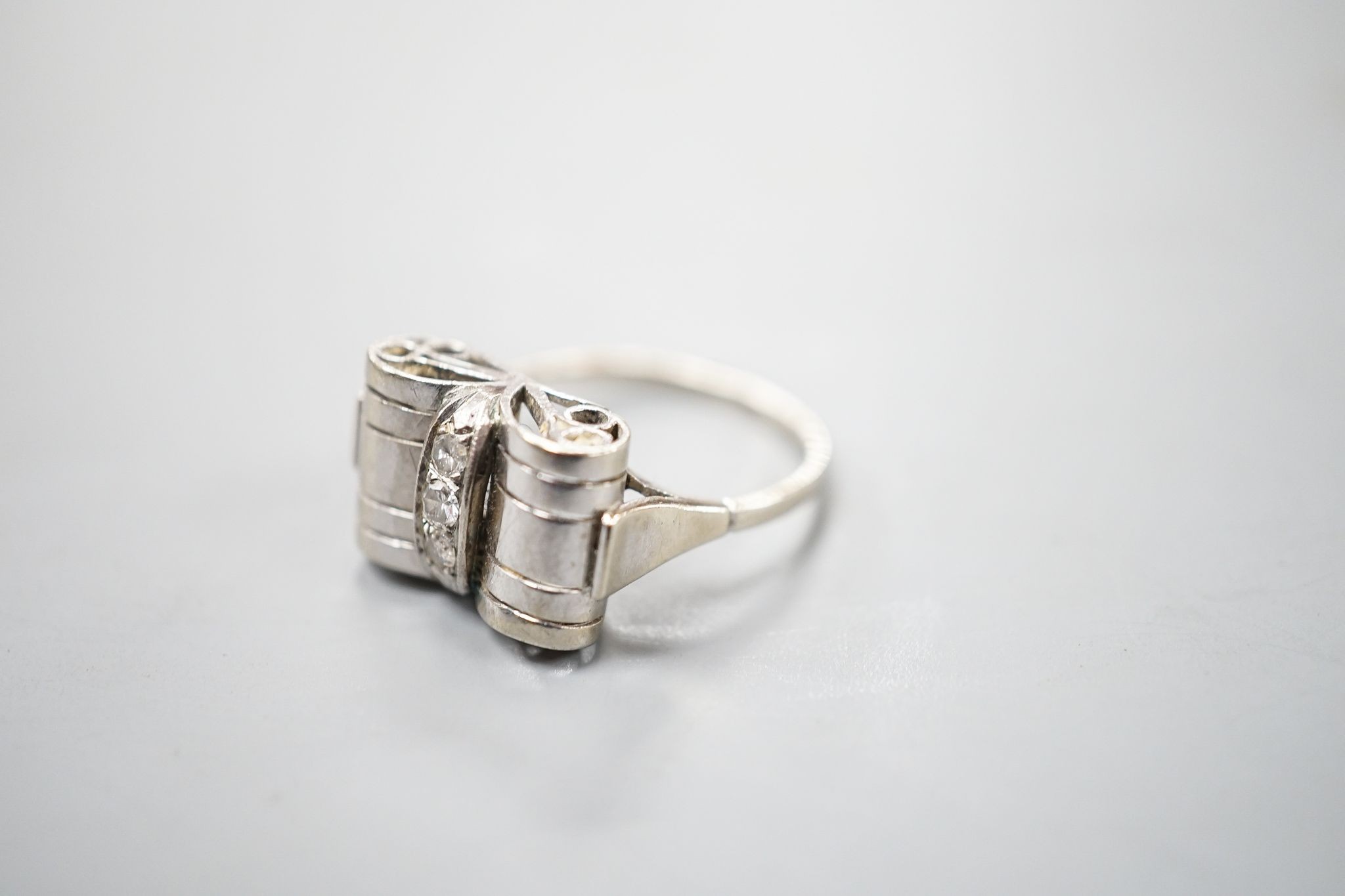 A 1940's white metal and three stone diamond set dress ring, size P, gross weight 3.5 grams.